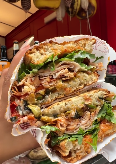 A stuffed Palermo street-food sandwich packed with turkey, greens and fried vegetables