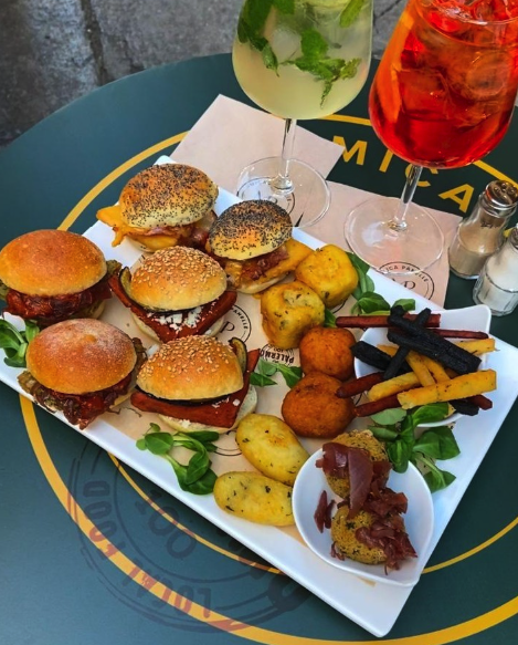 A Sicilian aperitivo platter of mini sandwiches, croquettes and drinks